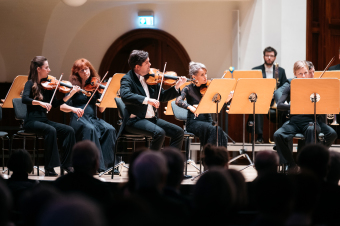 Blick auf die Bühne, wo Musikerinnen und Musiker ein klassisches Konzert geben