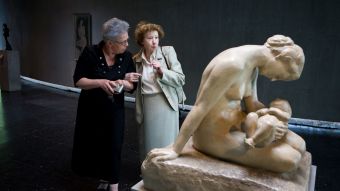 Zwei Frauen stehen in einem Museum vor einer Skulptur