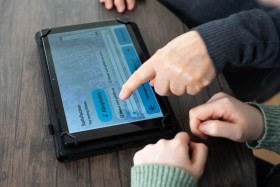 Eine Person navigiert mit dem Finger auf einem Tablet, auf dem sich die App "Musik und Demenz" befindet.